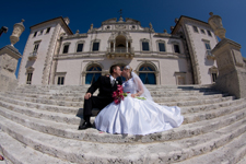 wedding photo of bride and groom kissing on stairs of luxurious mansion