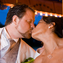wedding portrait of bride and groom kissing on carousel